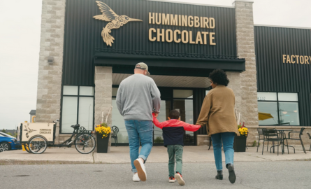 a family holds each other's hands while walking into a chocolate store