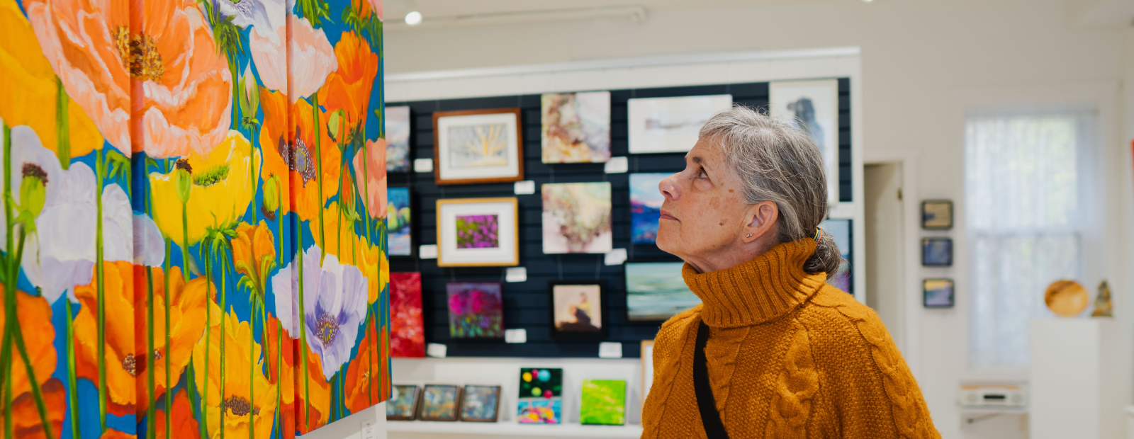 a woman looking at colourful art