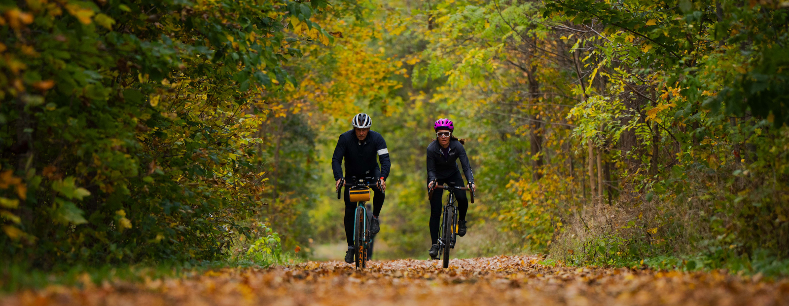 two cyclists ride along a trail 